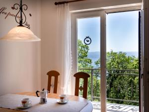 a dining room table with a view of a balcony at Holiday Home Orbani by Interhome in Lovran