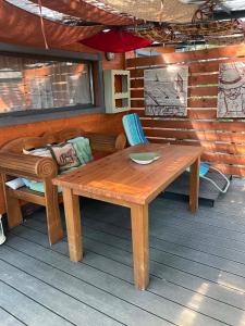 a wooden table and a bench on a porch at Makkocska Vendégház in Noszvaj