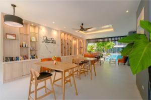 a restaurant with tables and chairs and a pool at Aree Tara Ao Nang Krabi in Ao Nang Beach