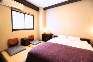 a bedroom with a bed and two chairs and a window at K's House Tokyo Oasis - Quality Hostel in Asakusa in Tokyo