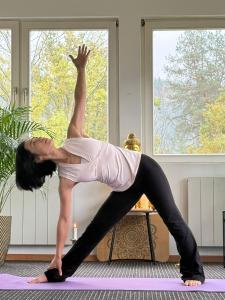 a woman doing a yoga pose on a yoga mat at VATTERSGARDEN GmbH in Viechtach