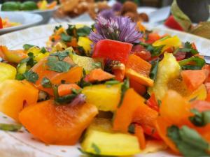 a plate of fruit salad with a purple flower on it at VATTERSGARDEN GmbH in Viechtach