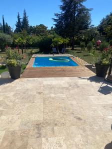 a swimming pool in a yard with a wooden deck at Chez Katty in Régusse