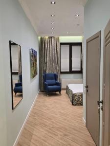 a hospital room with a bed and two blue chairs at Njala Residence in Stantsiya Tekeli