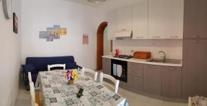 a kitchen with a table and a kitchen with a table and chairs at Casa Nespolo in San Vito lo Capo