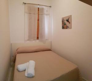 a small bedroom with a bed and a window at Casa Nespolo in San Vito lo Capo