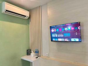 a flat screen tv on the wall of a room at LEAF HoteL in Jakarta