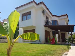 a white house with a green lawn in front of it at Süreyya Hanım Otel in İzmir