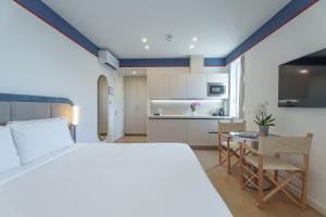 a bedroom with a bed and a desk and a kitchen at Vi Place in Lido di Camaiore