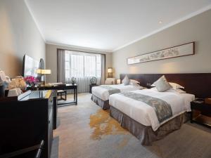 a hotel room with two beds and a desk at Garden Hotel Suzhou in Suzhou +43 photos