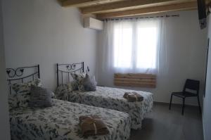 a bedroom with two beds and a window at Casa Rural El Capricho in Casas del Monte