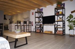 a living room with a flat screen tv and shelves at Casa Rural El Capricho in Casas del Monte
