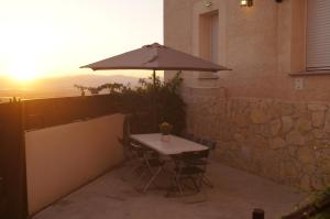 a table and chairs with an umbrella on a patio at Casa Rural El Capricho in Casas del Monte