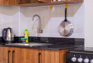 a kitchen with a sink and a stove at Caramel Studio In CBD with Free WI-FI in Nanyuki +3 photos