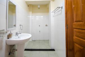 a white bathroom with a sink and a shower at Caramel Studio In CBD with Free WI-FI in Nanyuki