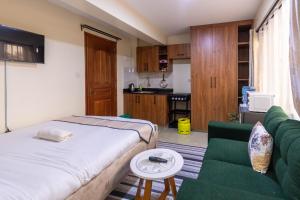 a bedroom with a bed and a couch and a table at Caramel Studio In CBD with Free WI-FI in Nanyuki