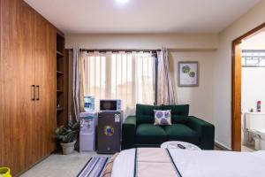 a bedroom with a green couch and a green chair at Caramel Studio In CBD with Free WI-FI in Nanyuki