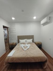 a bedroom with a large bed with a person laying on it at SeiaVilla - São Pedro in Seia