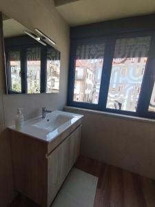 a bathroom with a sink and two windows at SeiaVilla - São Pedro in Seia +21 photos