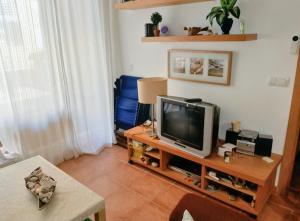 a living room with a television on a table at Pescadors in Les Cases d'Alcanar