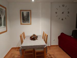 a dining room with a table and a clock on the wall at Pescadors in Les Cases d'Alcanar +4 photos