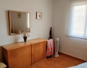 a room with a wooden dresser with a mirror at Pescadors in Les Cases d'Alcanar