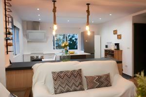 a living room with a white couch and a kitchen at Villa Raziel in Cártama