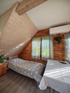 a attic bedroom with a bed and windows at ekoLOKUM in Ostróda
