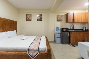 a bedroom with a large bed and a kitchen at Rustic Studio in CBD with free WI-FI in Nanyuki