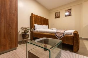 a hotel room with a bed and a glass table at Rustic Studio in CBD with free WI-FI in Nanyuki