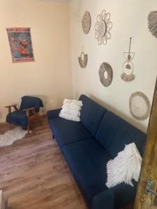 a living room with a blue couch in a room at Casa Siesta apartman in Makó