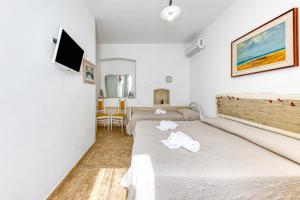 a hotel room with two beds and a tv at Masseria Prisuti in Punta Prosciutto