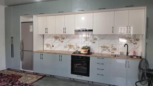 a kitchen with white cabinets and an oven at Guest House FAIZ homestay in Panjakent