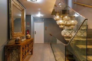 a hallway with a staircase with a mirror and chandelier at Casa da Praça - Alojamento Local in Sesimbra