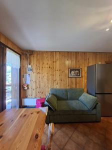 a living room with a couch and a refrigerator at Dolomites View Apartment - Mountain Relax Experience in Cibiana