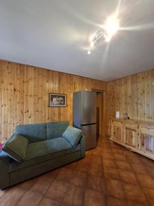 a living room with a couch and a refrigerator at Dolomites View Apartment - Mountain Relax Experience in Cibiana