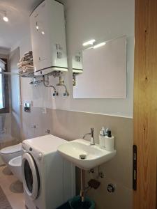 a bathroom with a sink and a washing machine at Dolomites View Apartment - Mountain Relax Experience in Cibiana +30 photos