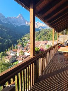 a balcony with a view of a town and mountains at Dolomites View Apartment - Mountain Relax Experience in Cibiana