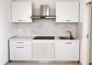 a white kitchen with white cabinets and a sink at Casa Mare con finestra su balcone in Polignano a Mare