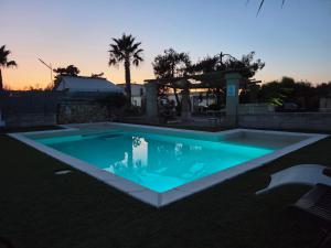 a swimming pool in a backyard at dusk at Masseria Prisuti in Punta Prosciutto