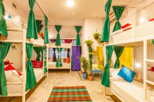 a room with bunk beds with green curtains at goSTOPS Jaipur, Civil Lines in Jaipur