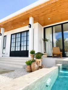a house with a swimming pool in front of it at Tim Kanya Pranburi in Pran Buri