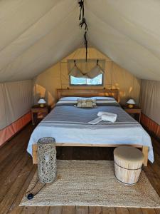 a bedroom in a tent with a bed and a stool at Masseria Prisuti in Punta Prosciutto +138 photos