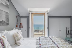 a bedroom with a bed and a view of the ocean at Casa da Praça - Alojamento Local in Sesimbra