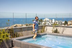 a man standing in a swimming pool at Hermanus Waterfront Apartments in Hermanus +2 photos
