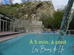 a pile of people in a swimming pool with a mountain in the background at Gîte de Llo - Vue Pyrénées, chambres & PDJ inclus in Llo