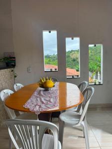 a dining room table with chairs and a bowl of bananas on it at Aconchego Da Serra in Triunfo