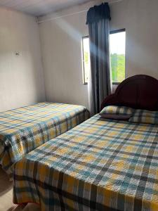 a bedroom with two beds and a window at Aconchego Da Serra in Triunfo