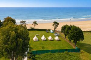 a group of tents on a field near the beach at Kampaoh Oyambre in El Tejo