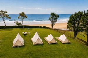 a group of four tents in a field near the beach at Kampaoh Oyambre in El Tejo